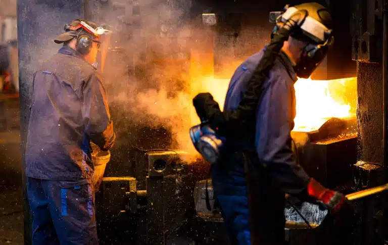 Two blacksmiths in front of a hammer