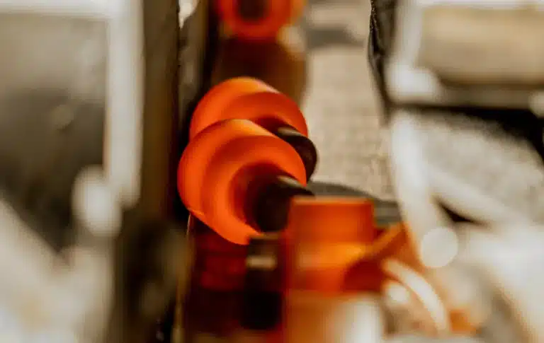 Warm-forged shafts on a conveyor coming out of the press