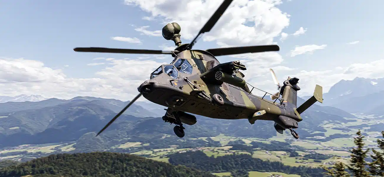 Page-Marchés-DEFENCE-7-2 Military helicopter flying over a landscape
